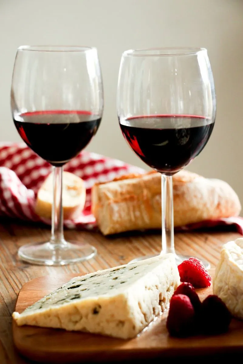 Bouteilles, fromages et pain sur une table de l'épicerie fine