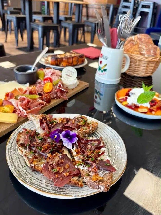 Tartine au magret séché, oignons confits et fleur comestible, servie au brunch de L'Annexe du Chai Gourmand